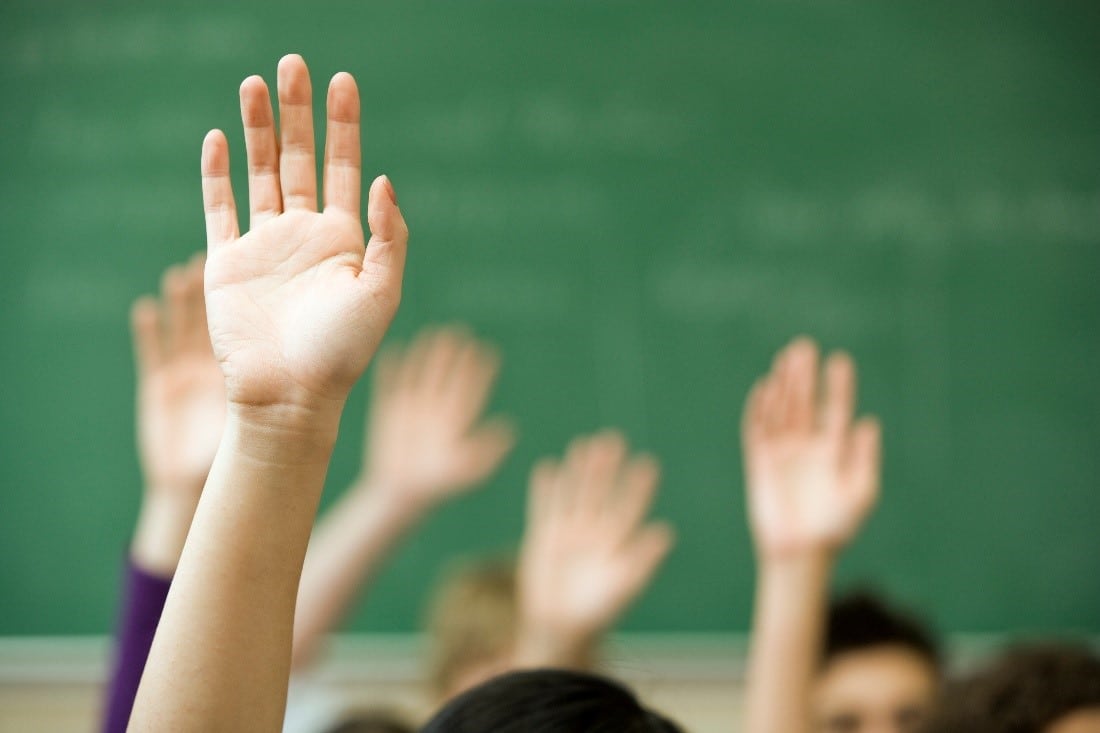 hands raised in classroom